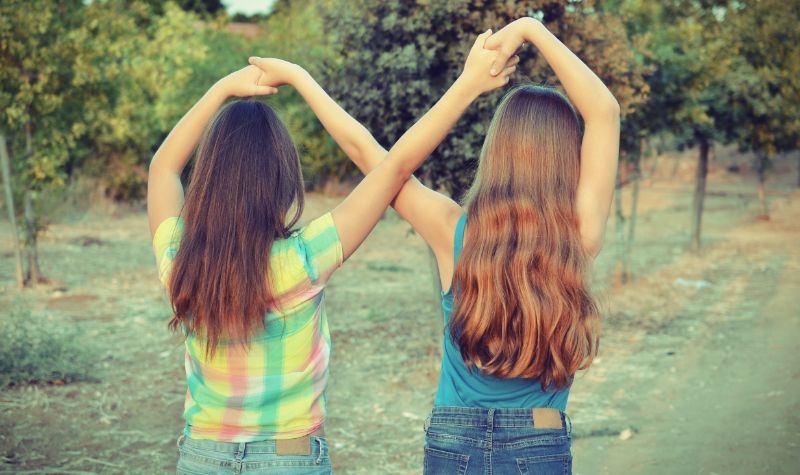 Dwie nastolatki przyjaciółki tyłem trzymające się za ręce | Hemorigen femina
